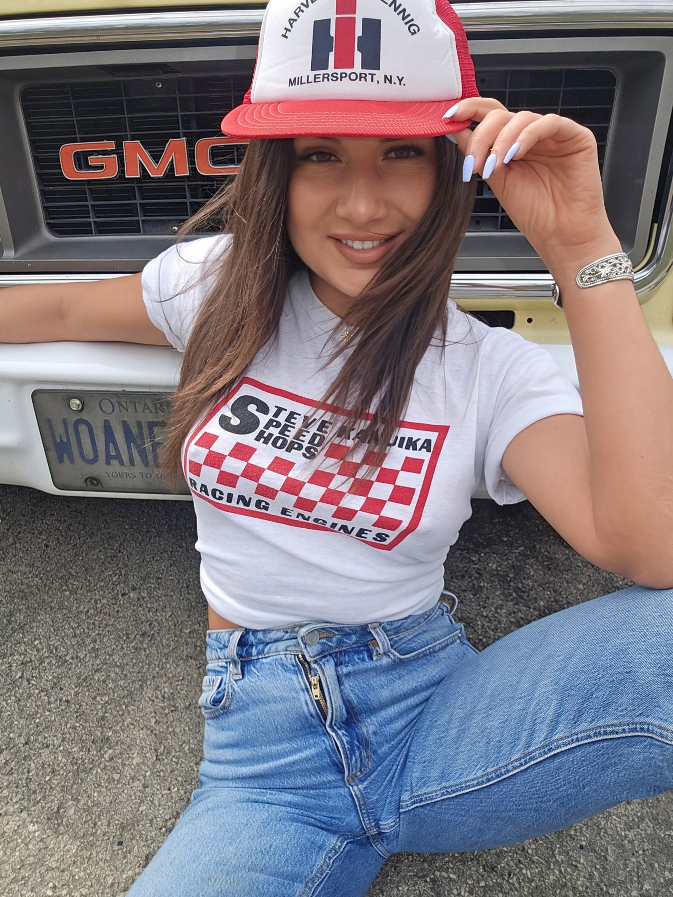 Nelly Weaver in a red trucker cap in front of a GMC grille